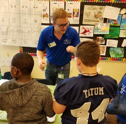 A Clorox employee leads Atlanta-area students in science experiments