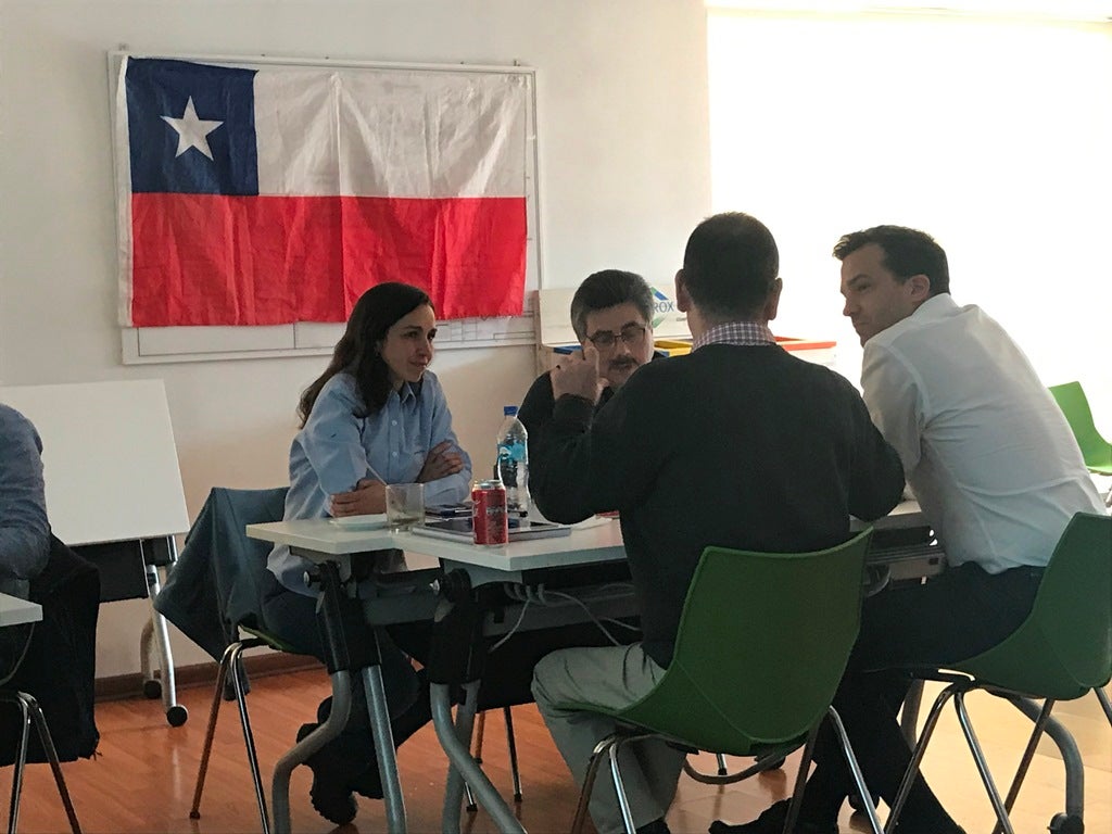 Clorox Chile employees talking in front of Chile flag